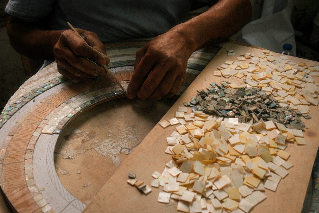 An artist carefully assembling a mosaic from small pieces of tile.